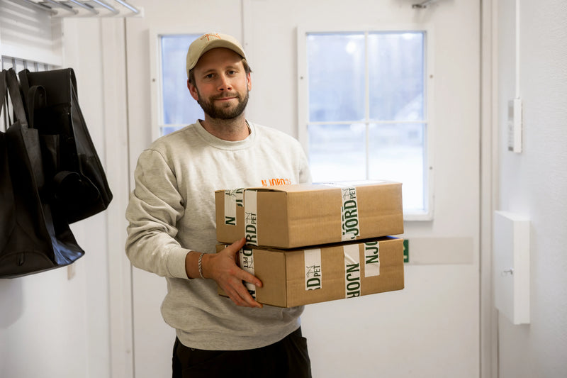 Pontus från Njord bär på handplockade lådor som ska levereras till butiker och kunder i sverige